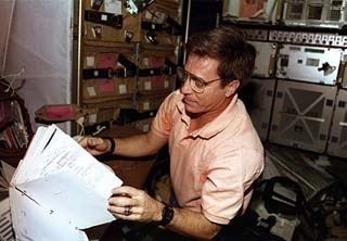 STS-79 mission specialist John Blaha, checklist in hand